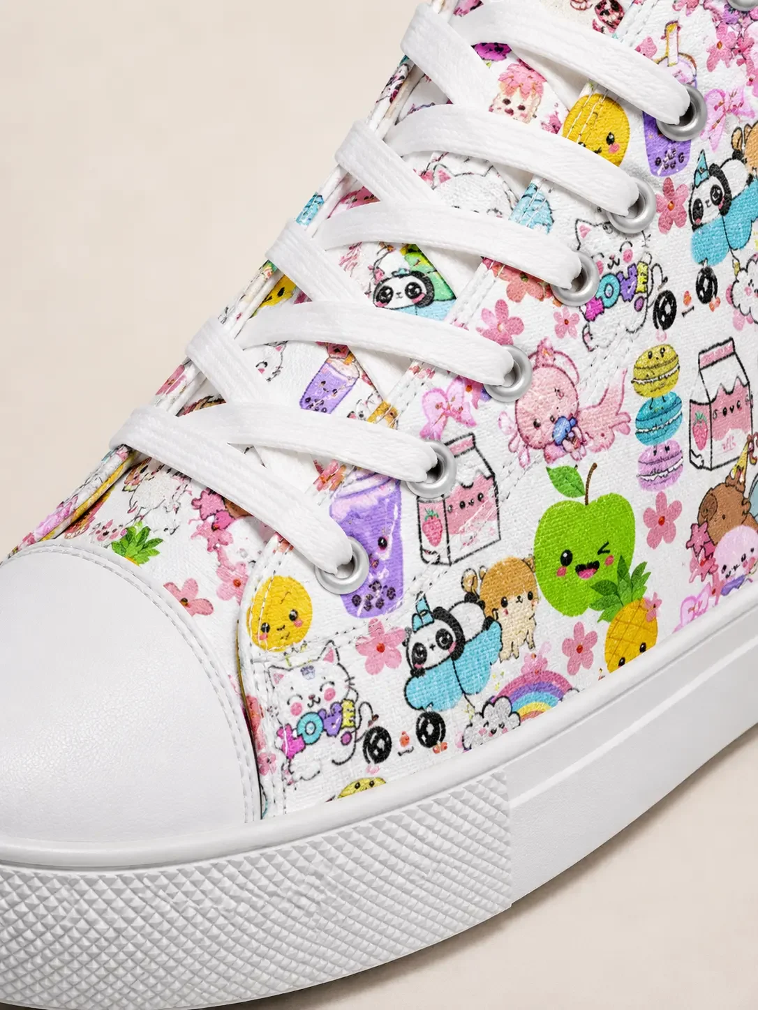 Close-up detail of white canvas shoelaces, eyelets, and a rubber sole with a colorful cartoon character print pattern.