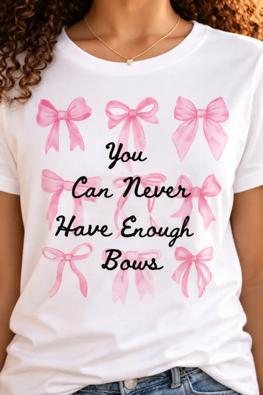 Close-up of a white graphic t-shirt with pink watercolor bows that reads You Can Never Have enough Bows.
