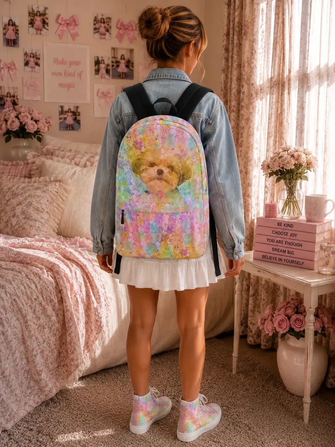 Rear view of a woman wearing a denim jacket and white skirt, featuring a colorful watercolor backpack printed with a small dog face and a rainbow floral pattern.