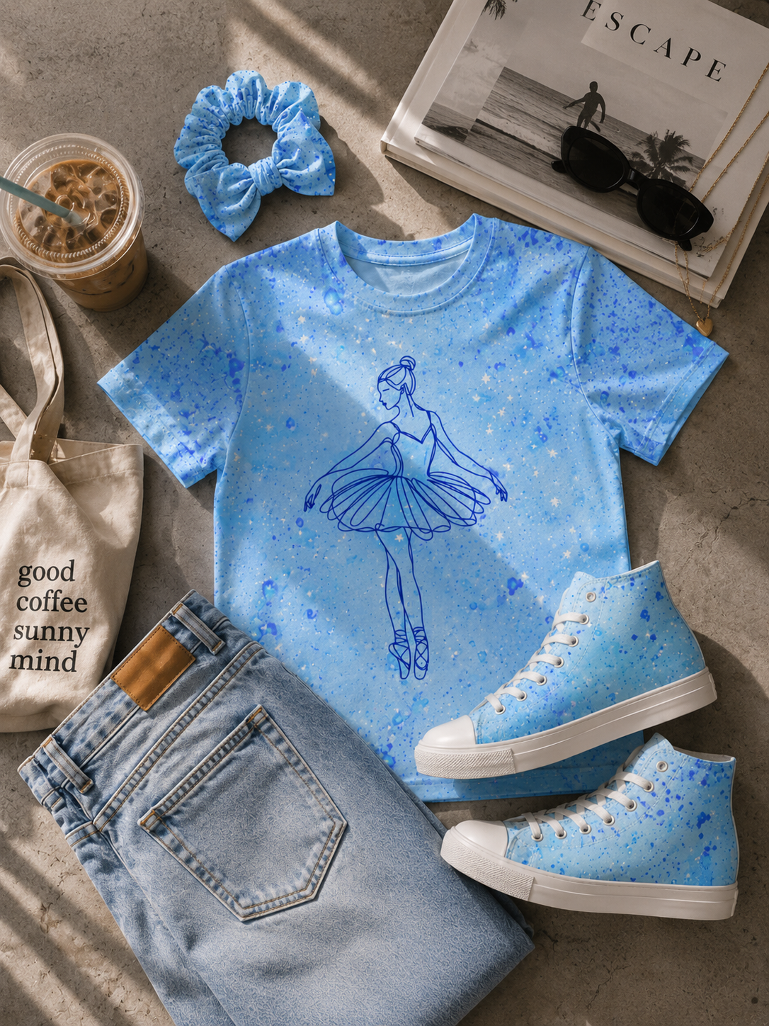 Flat lay of a blue ballerina t-shirt, light wash jeans, matching paint-splattered sneakers, and a scrunchie.