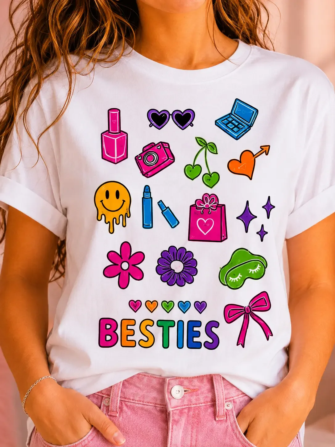 Close up of a white graphic tee featuring hand colored preppy doodles and rainbow gradient Besties text.
