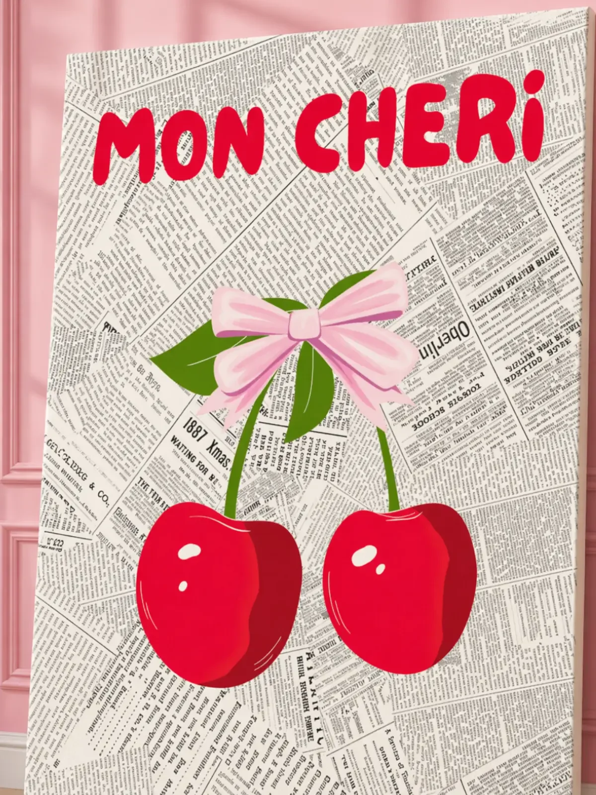 Close-up mockup of the Doodles and Saffron Mon Cheri canvas print showcasing vintage text and cherry textures near a pink wall.