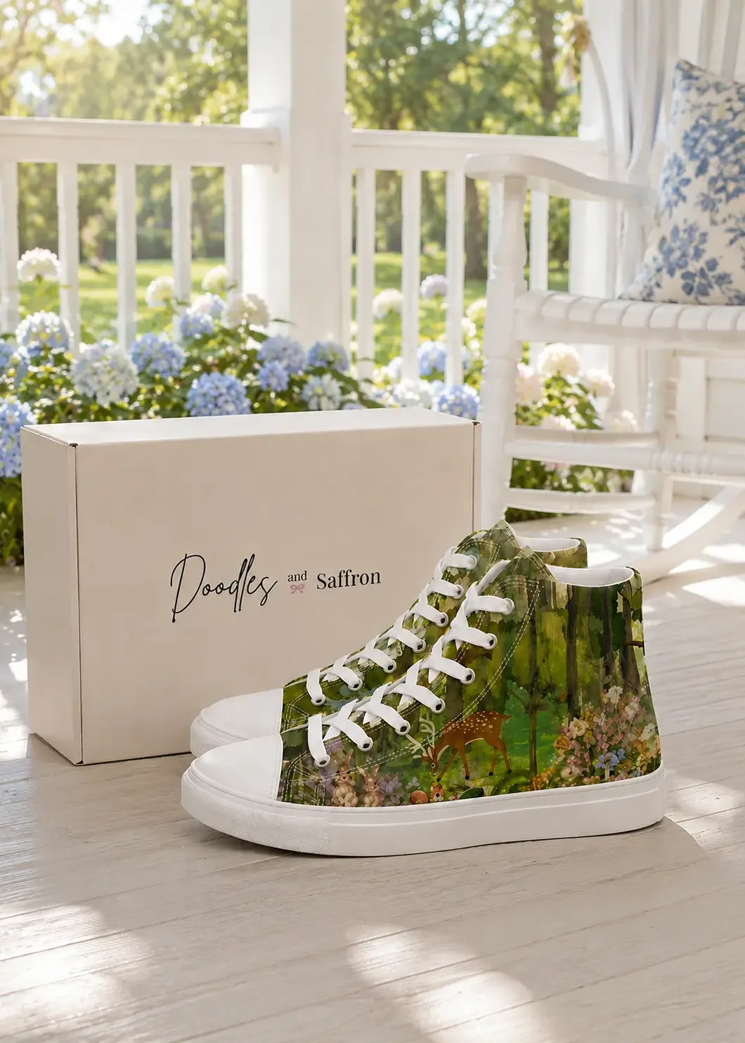 A pair of green forest woodland print high-top canvas sneakers displayed in front of a white Doodles and Saffron shoebox on a sunny porch.