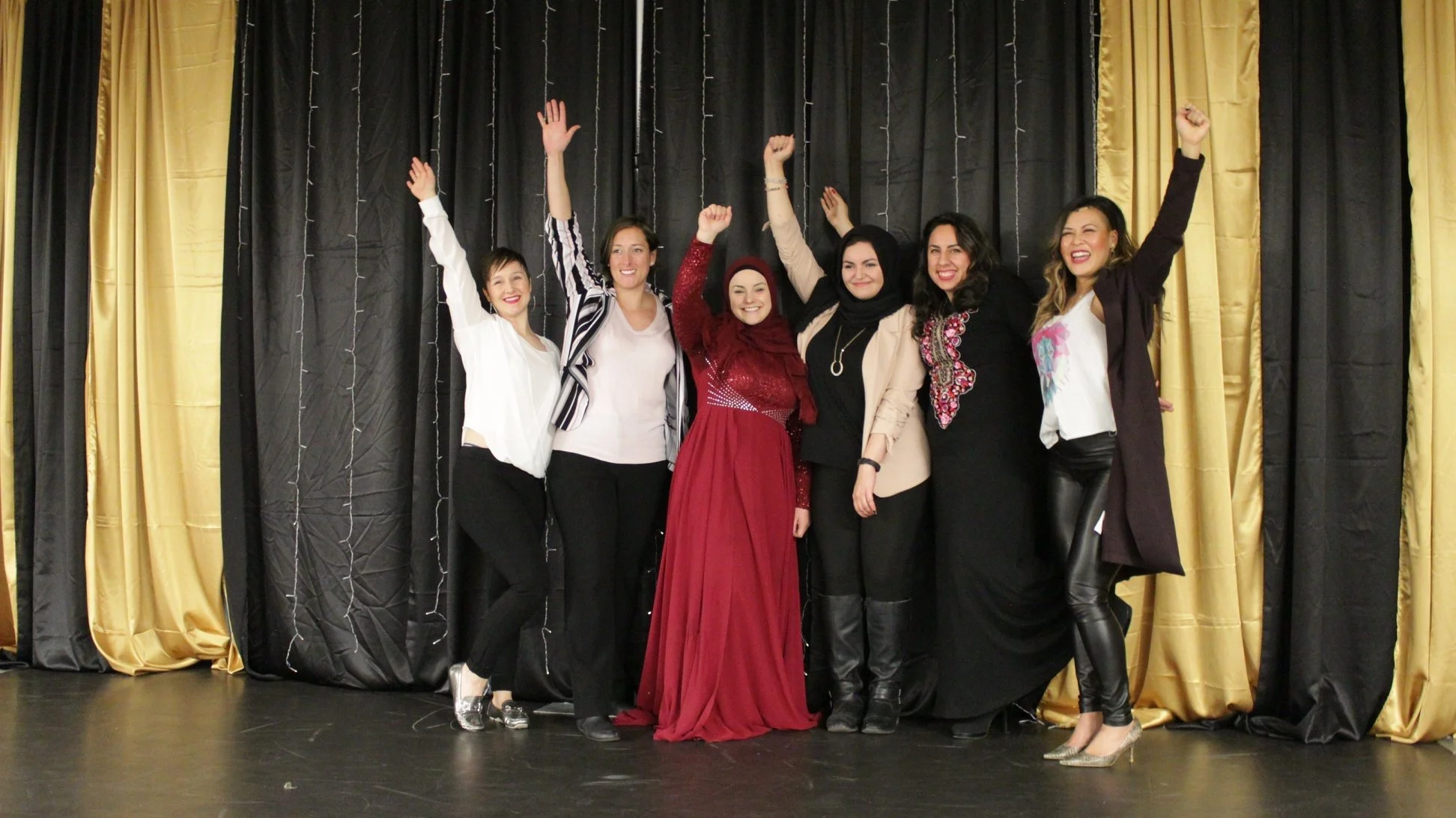 Speakers raise hands and celebrate women of faith conference with host Khadijah in Calgary, Alberta