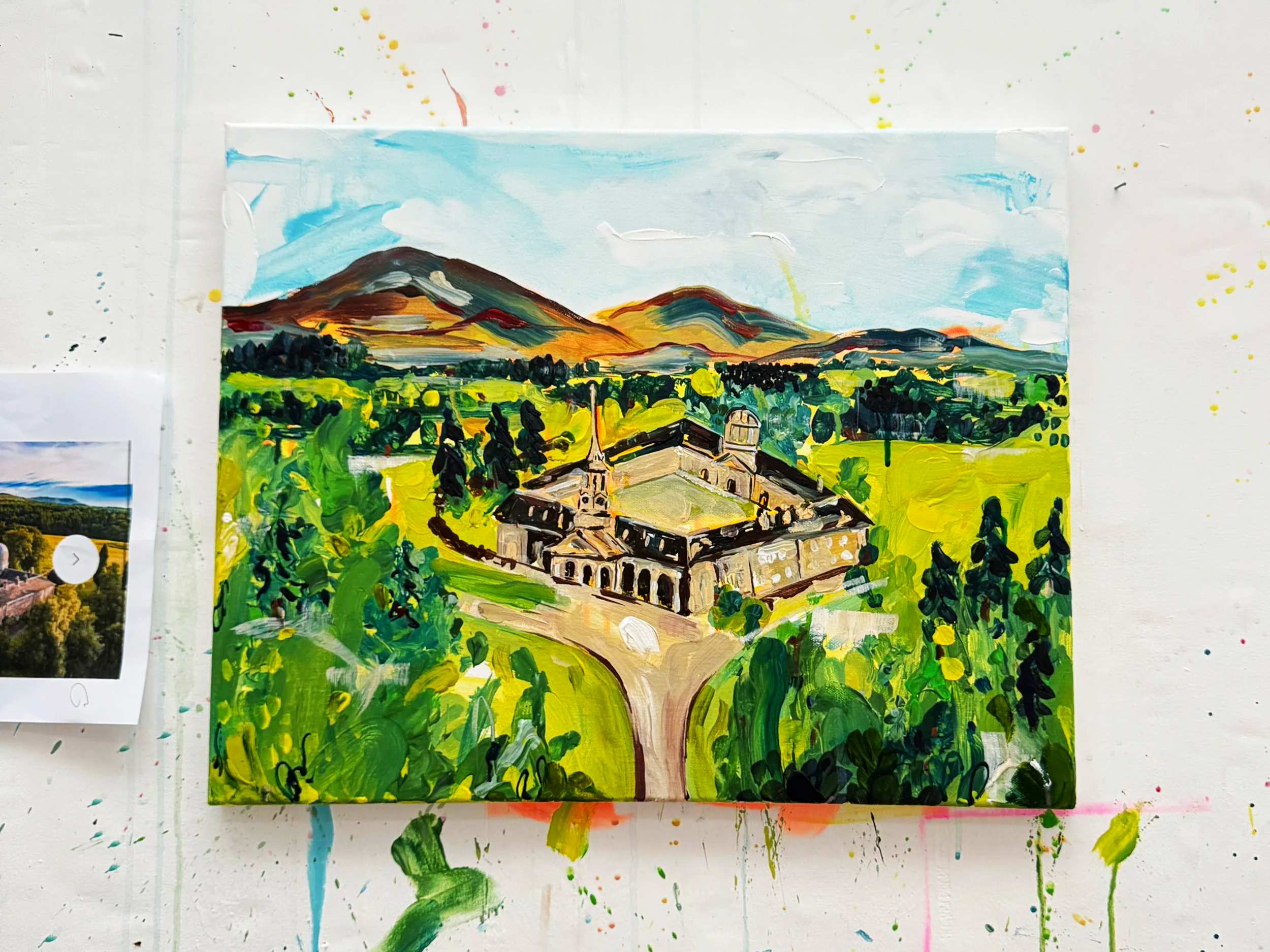 Colorful landscape painting of a historic building with a green landscape, mountains, and sky in the background.