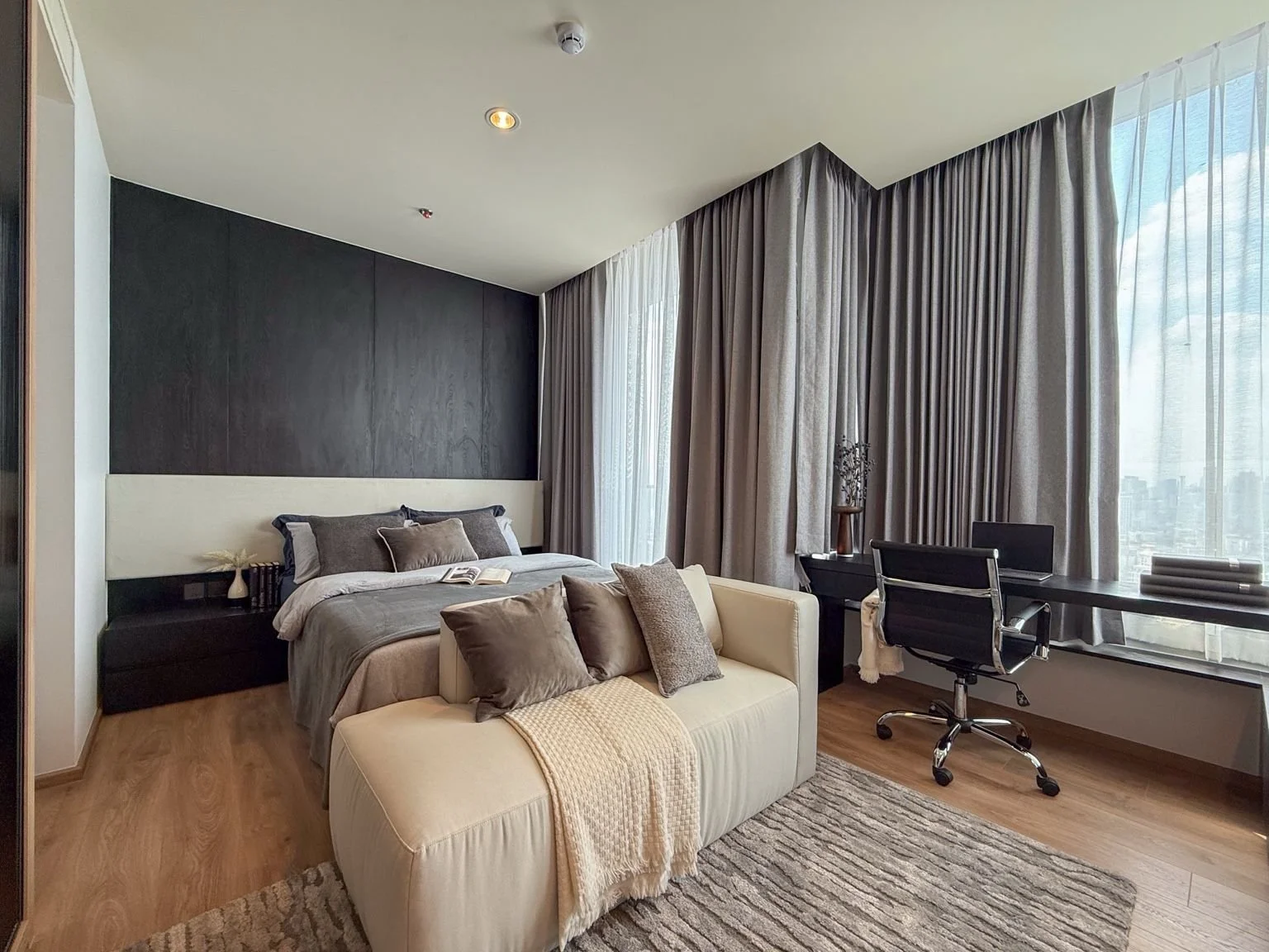 Bedroom with workspace at Noble Form Thonglor featuring desk and city views.