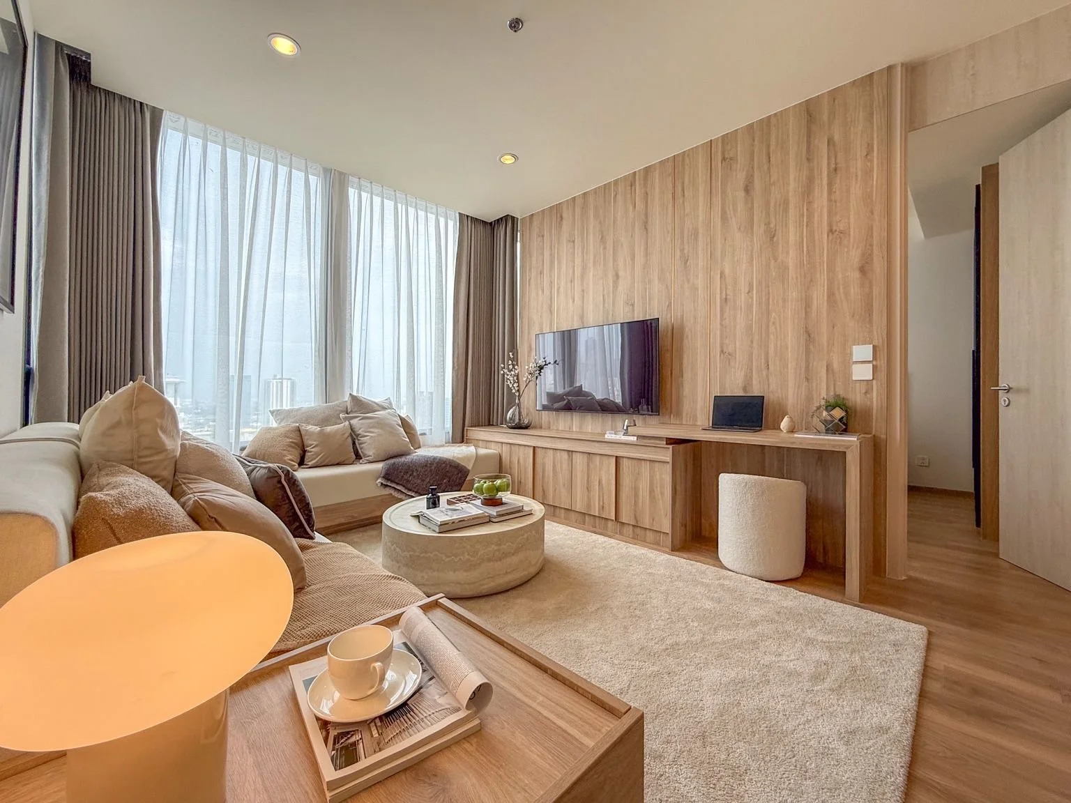 Modern living room at Noble Form Thonglor Bangkok with sofa, TV unit and built-in desk.