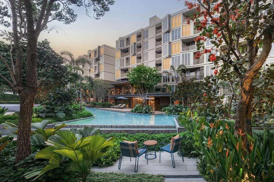 Mekin Haus Chiang Mai condominium with landscaped garden, swimming pool, and low-rise residential buildings.
