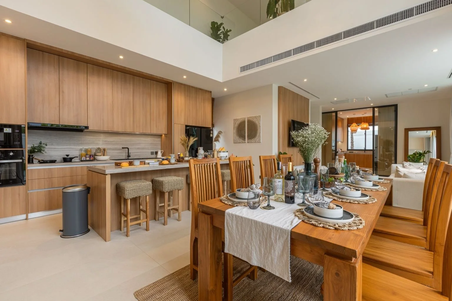 Elegant dining area and kitchen at Mouana Grande Chalong Bay villa with tropical décor and natural light.