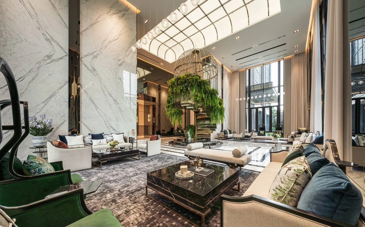 The Grande Chamber lobby lounge at The Address Siam–Ratchathewi with marble finishes, high ceilings and central feature staircase.