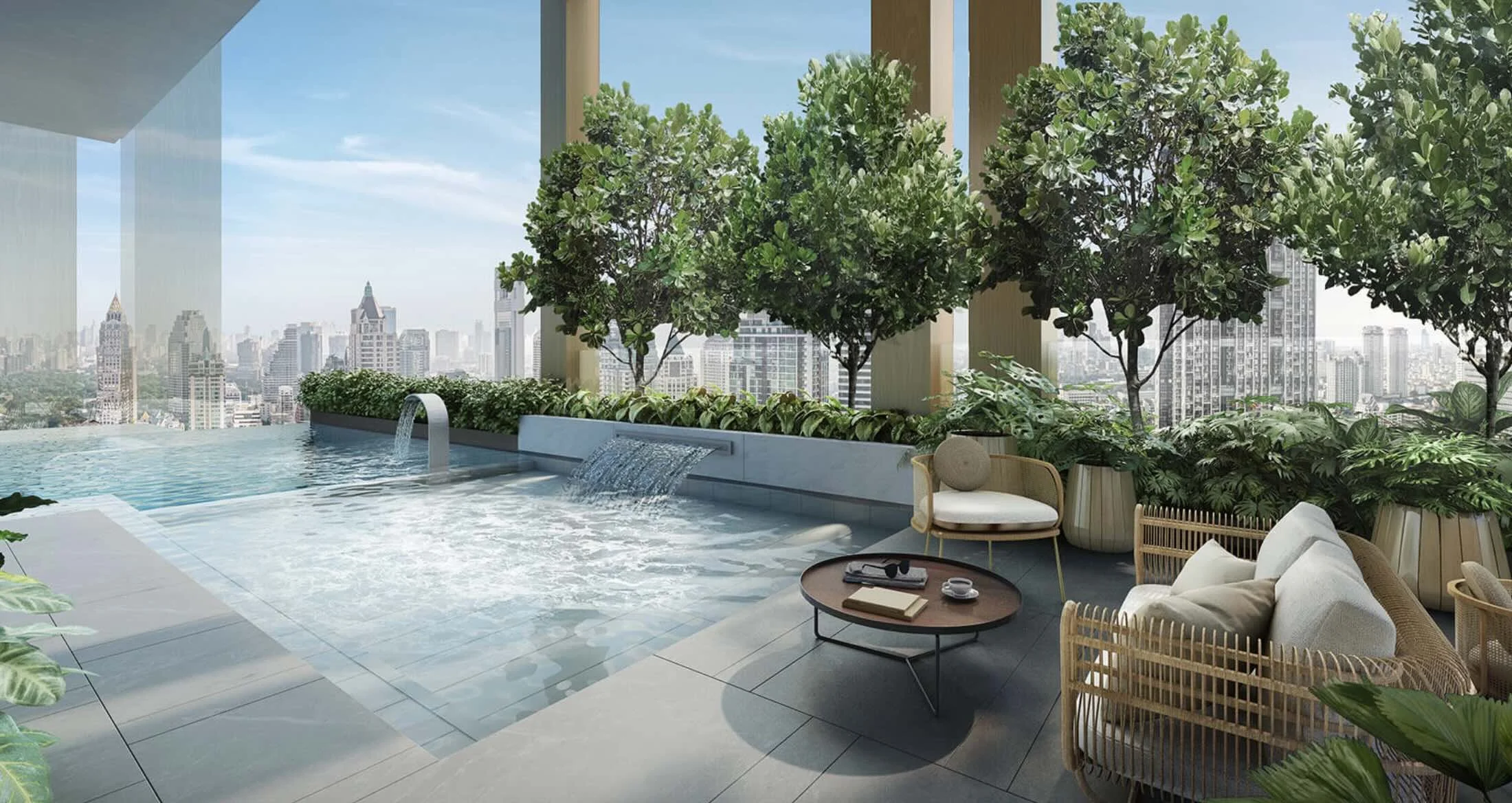 Pool terrace and lounge seating surrounded by greenery at Romm Convent, with panoramic views over central Bangkok.