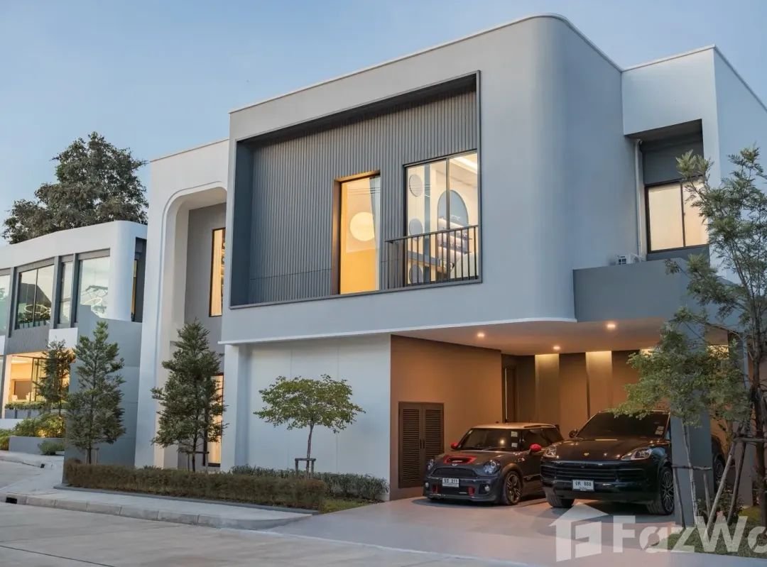 Modern two-storey Thera Asset villa in Chiang Mai with covered parking, contemporary architecture, and landscaped residential setting.