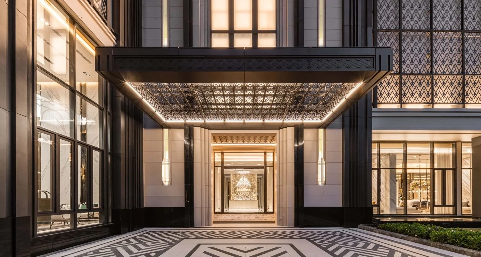 Grand entrance at The Address Siam–Ratchathewi with illuminated canopy, geometric detailing and formal arrival sequence.