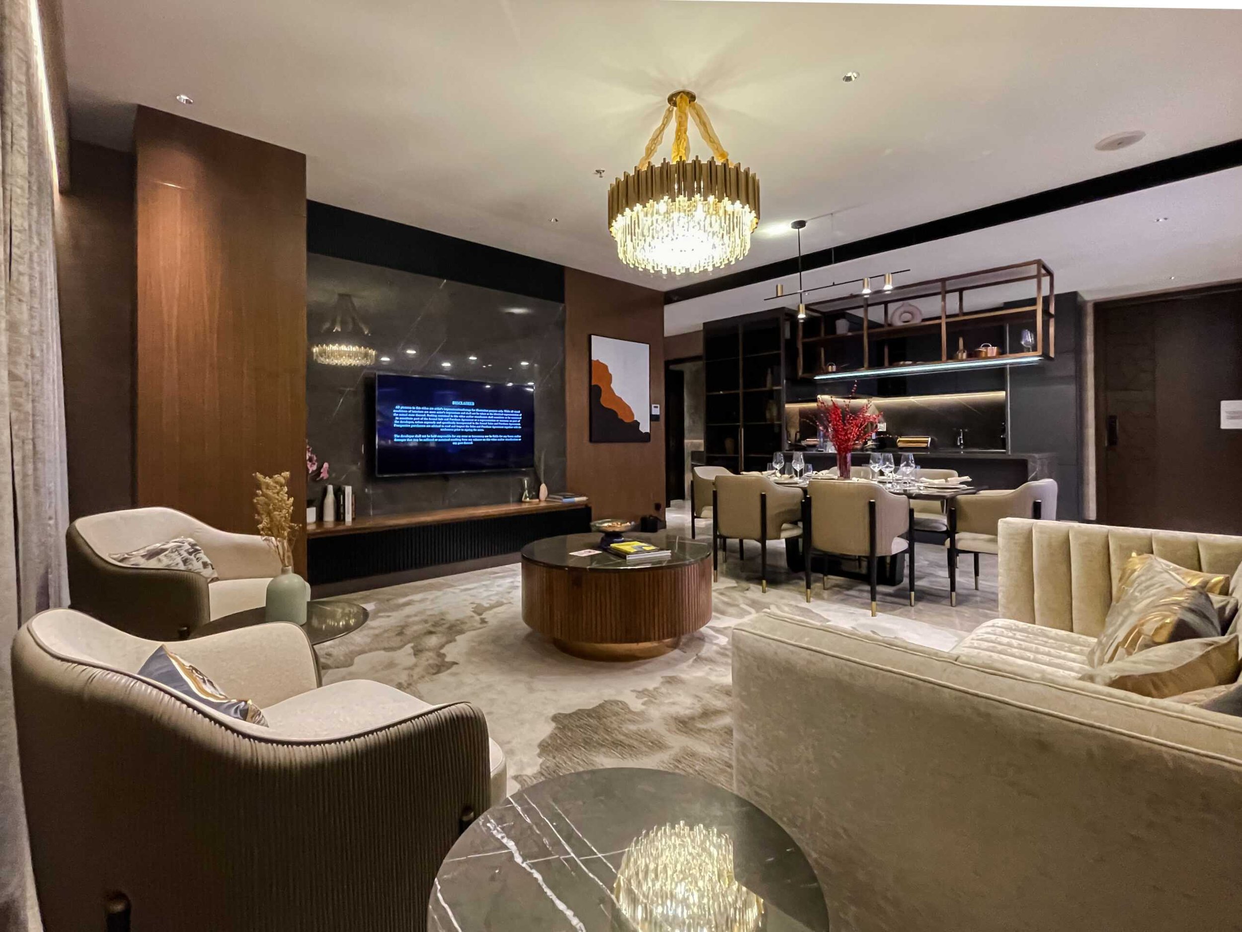 Open-plan living and dining room with chandelier and marble accents at Orion Residence.