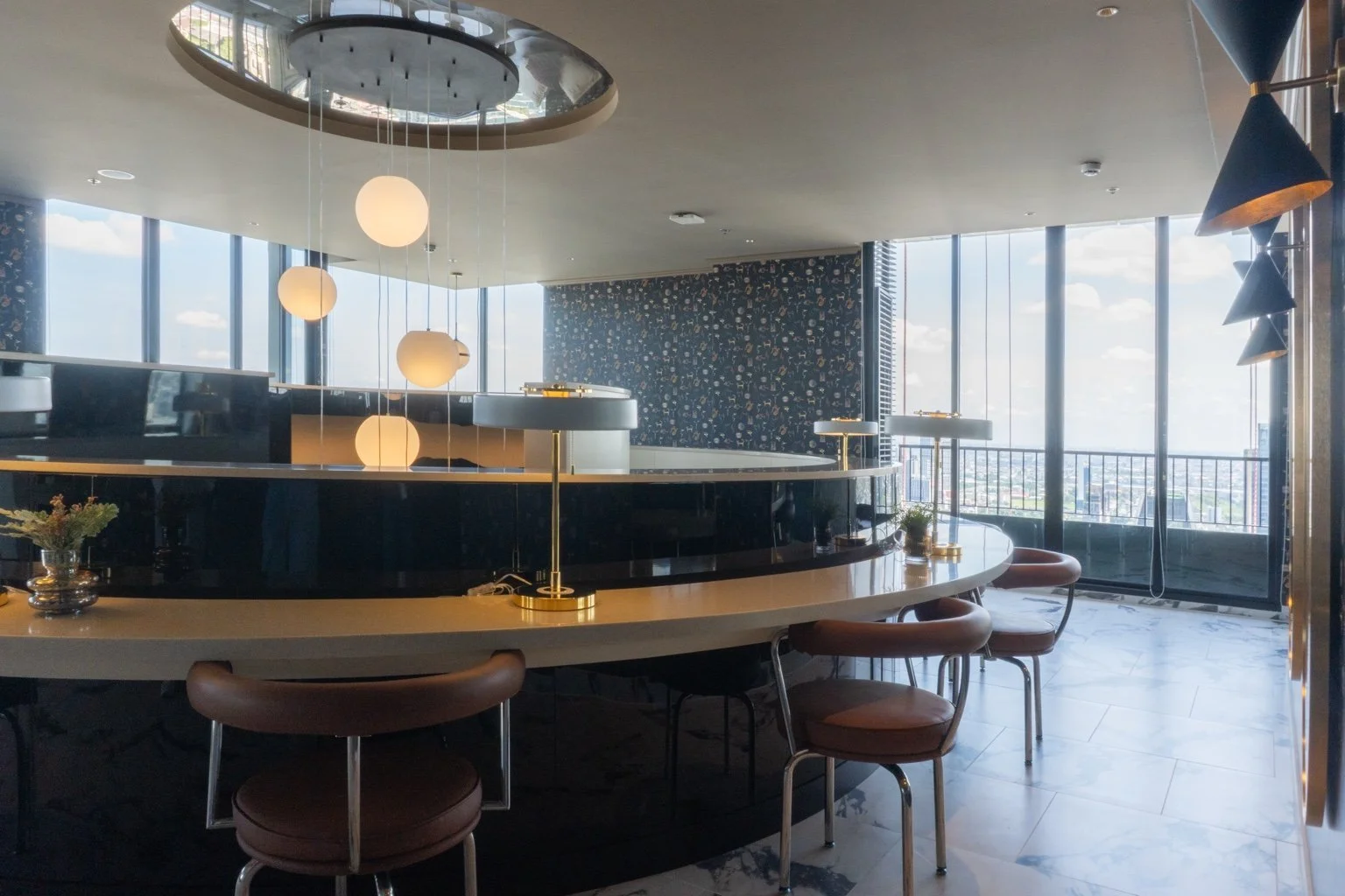Moon Bar at Noble Form Thonglor with curved counter seating and Bangkok skyline backdrop.