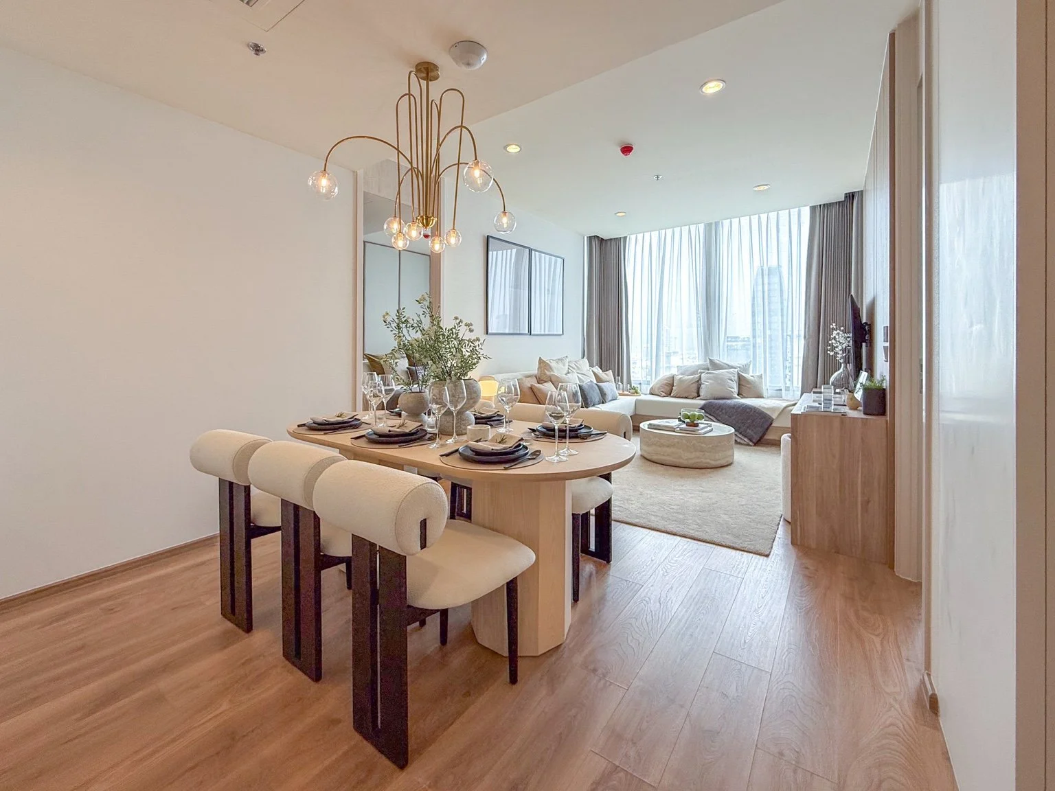 Open plan living and dining area at Noble Form Thonglor with natural light and seating.