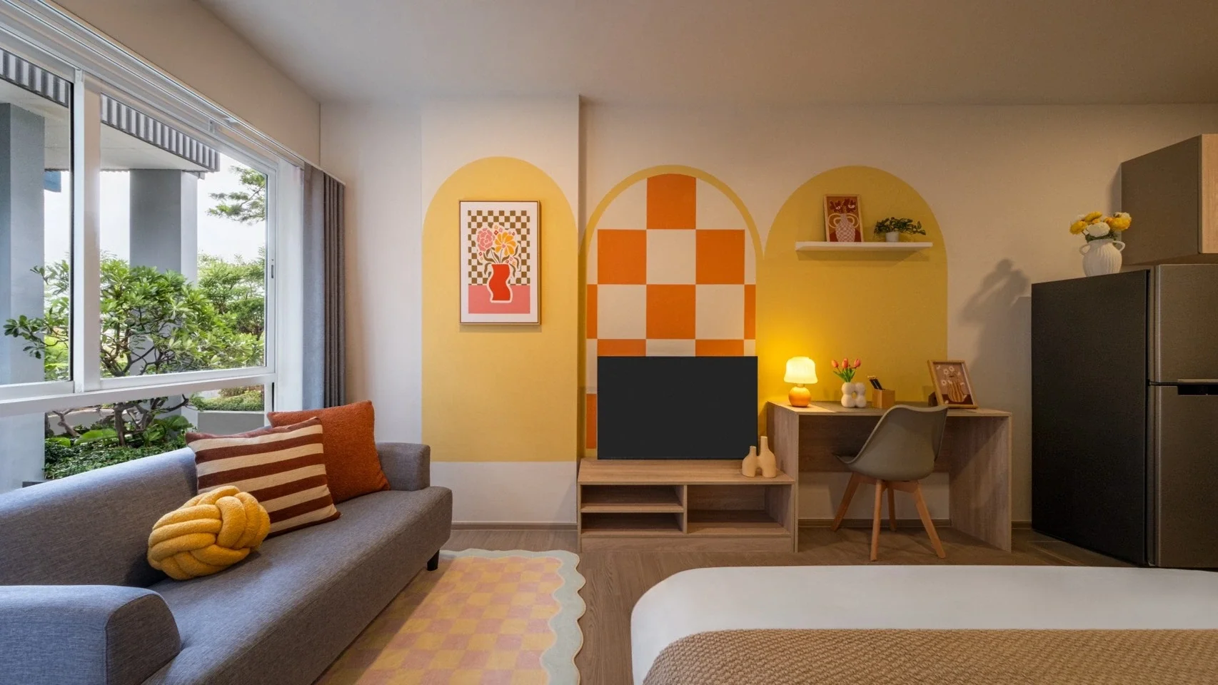 Studio condominium living area at Hub Hua Hin with contemporary colourful interiors, workspace and garden views.