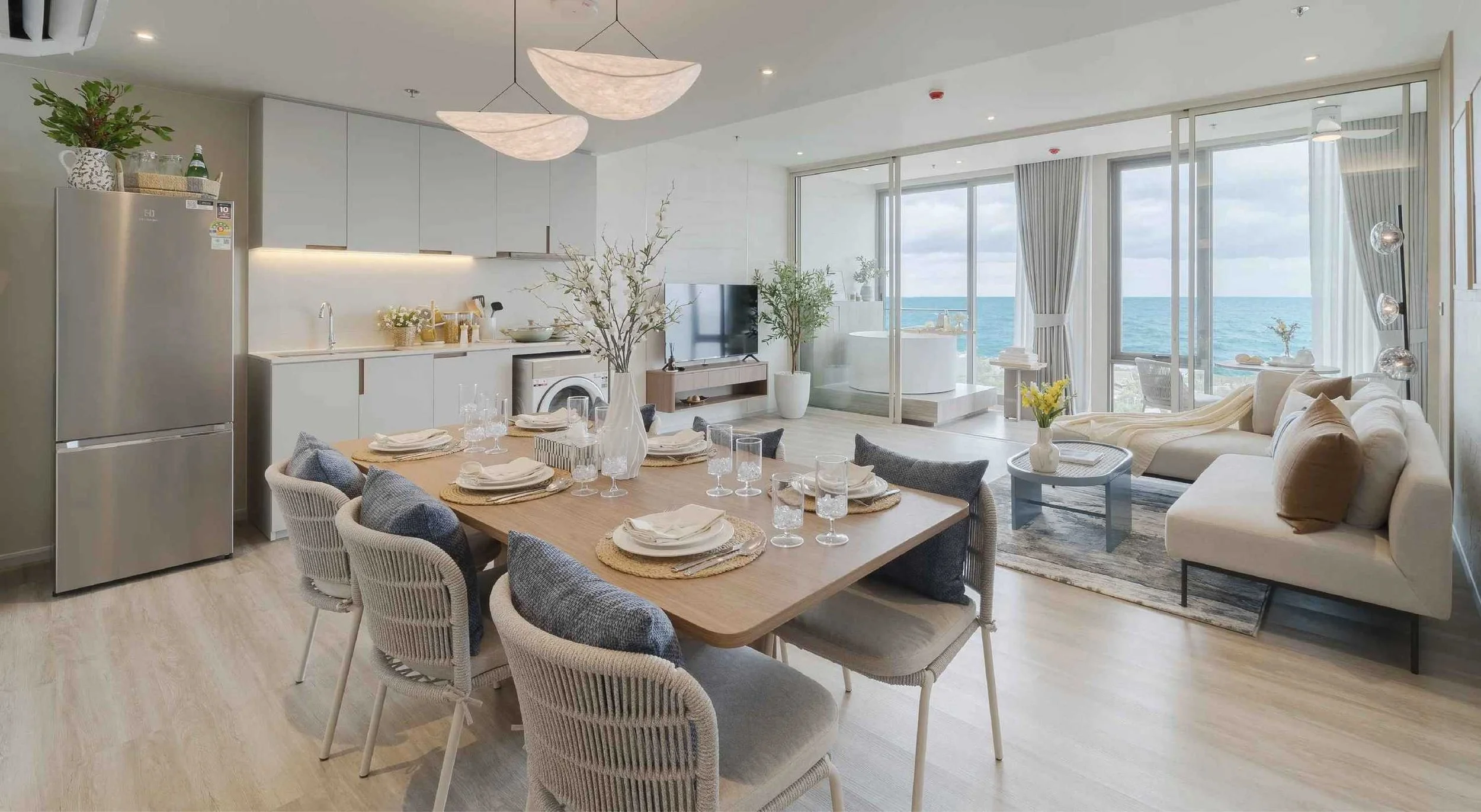Open-plan living and dining area at Vehha Hua Hin with sea views and modern kitchen in Hua Hin, Thailand.