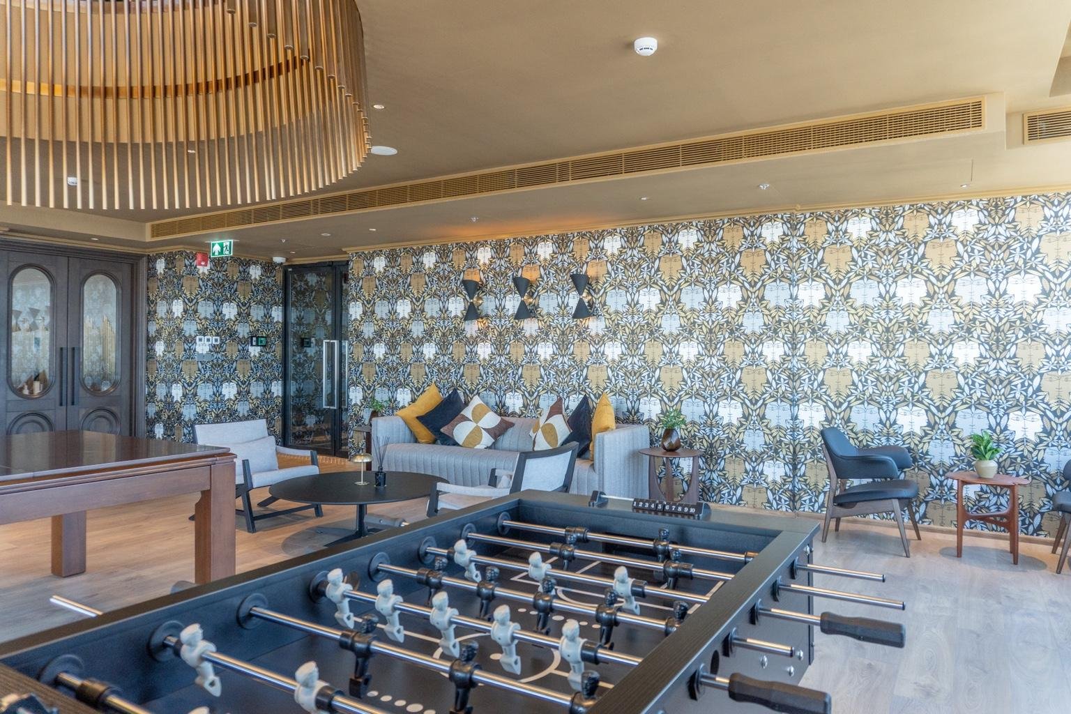 Games and social room at Noble Form Thonglor with table football and lounge seating.