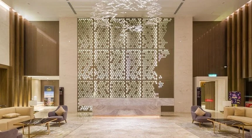 Elegant lobby seating area at Quill Residences with marble floors, plush armchairs, and ambient lighting.