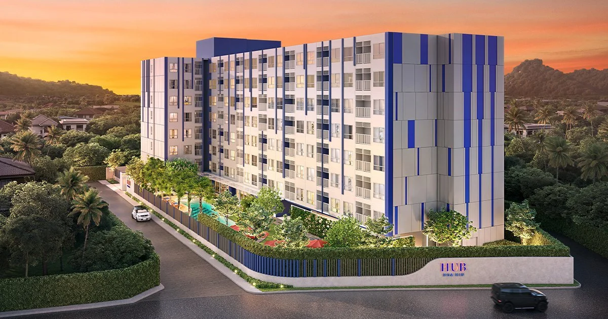 HUB Hua Hin condominium exterior at sunset with landscaped gardens and swimming pool.