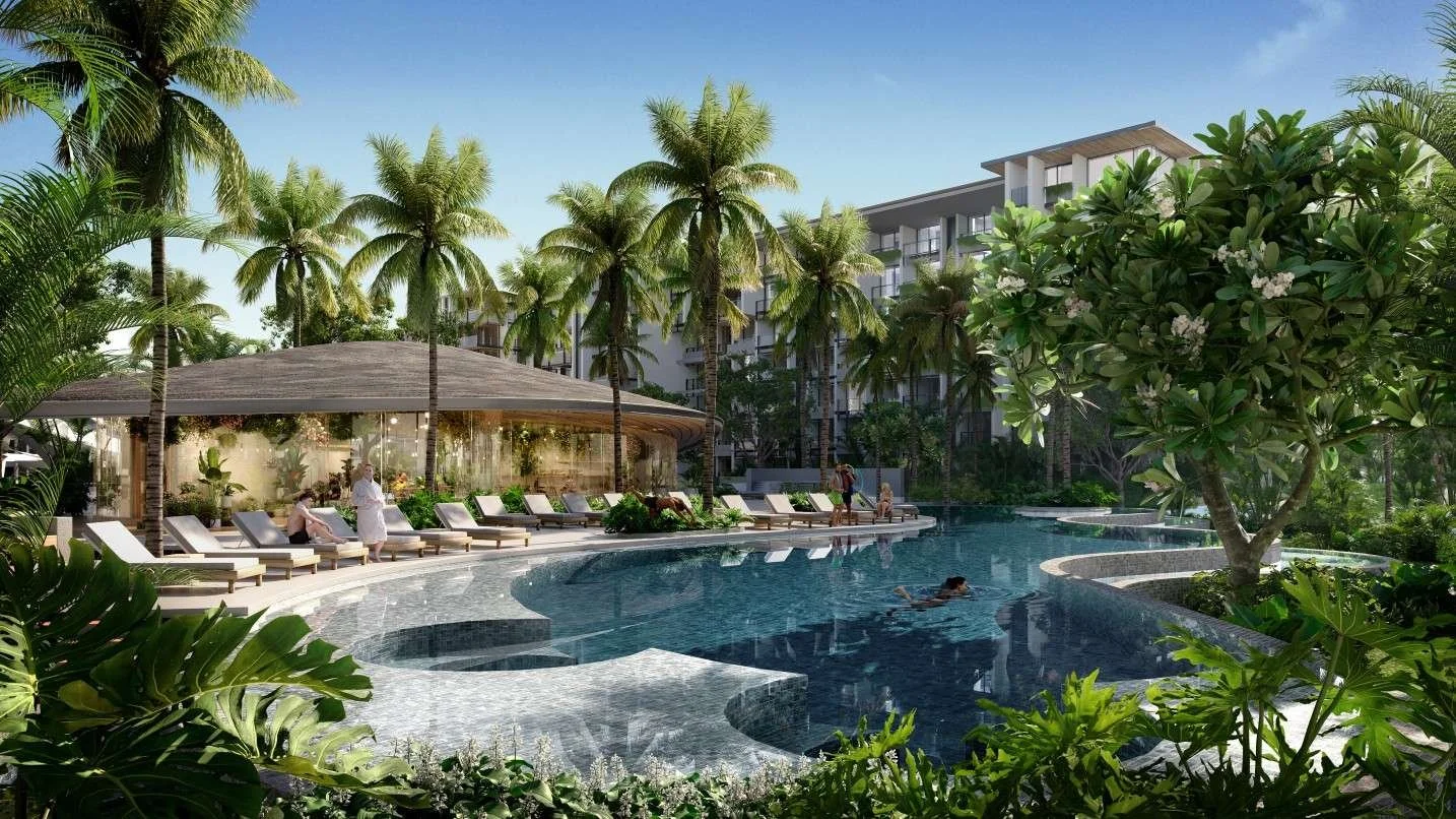 Lagoon-style swimming pool at Gardens of Eden Phuket surrounded by tropical landscaping, sun loungers and palm trees within the residential resort.