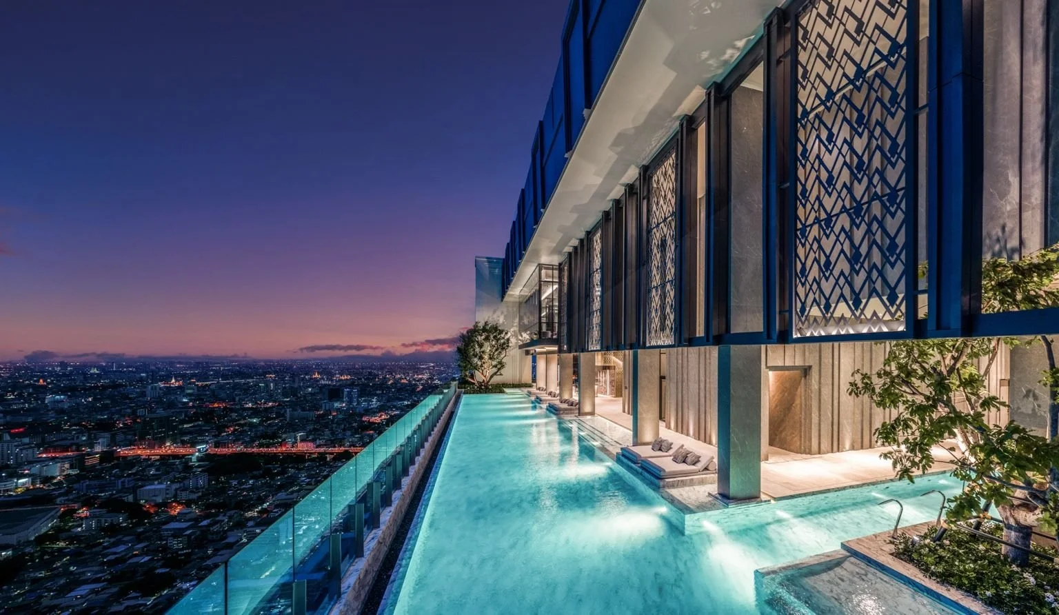 Sky Pool at The Address Siam–Ratchathewi at dusk with illuminated pool edge and panoramic Bangkok views.