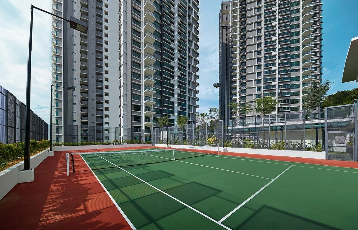 Tennis court at Alila² Penang surrounded by landscaped grounds and high-rise residential towers.