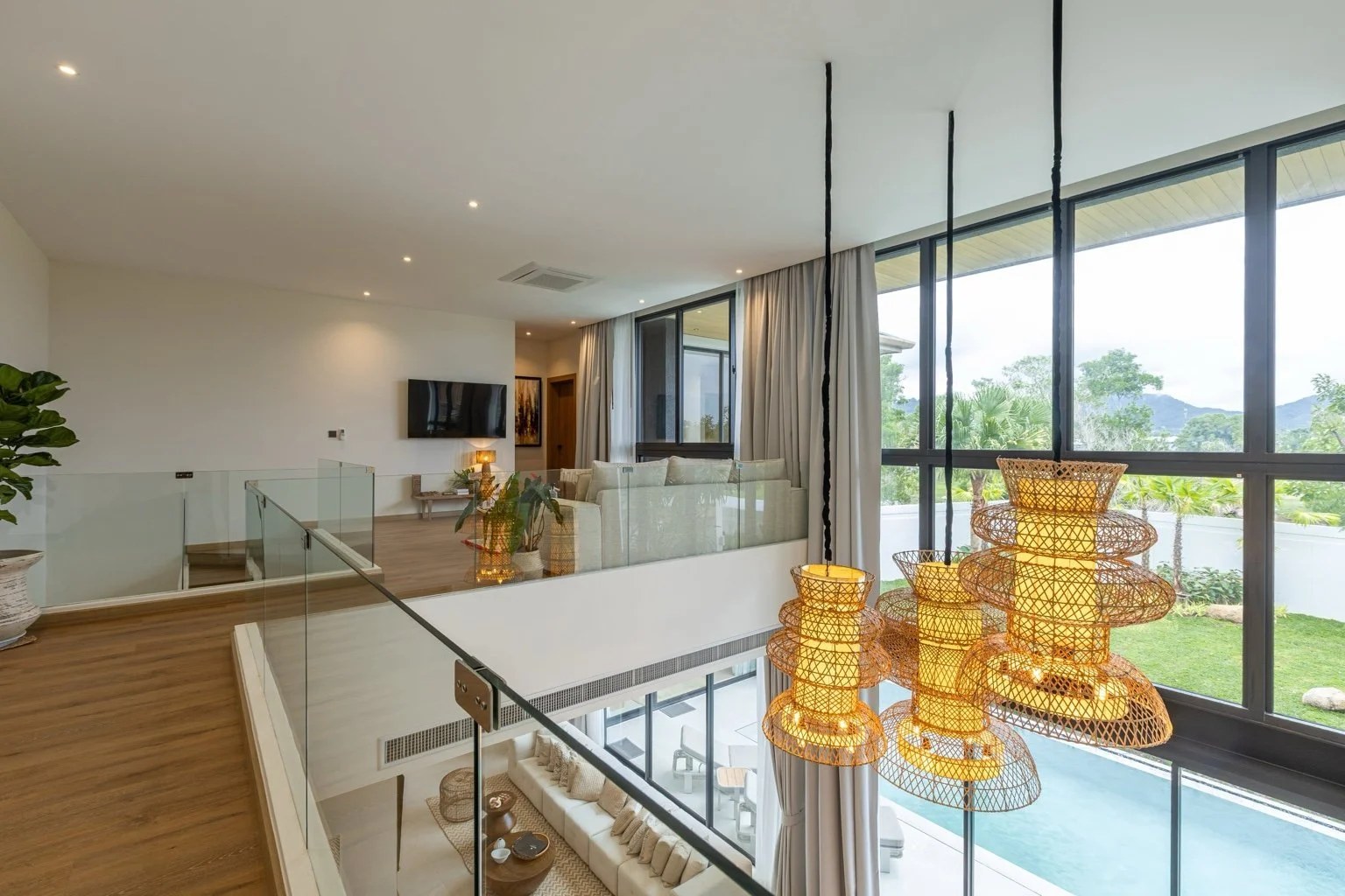Upper-level mezzanine lounge at Mouana Grande Chalong Bay overlooking the pool and tropical gardens.