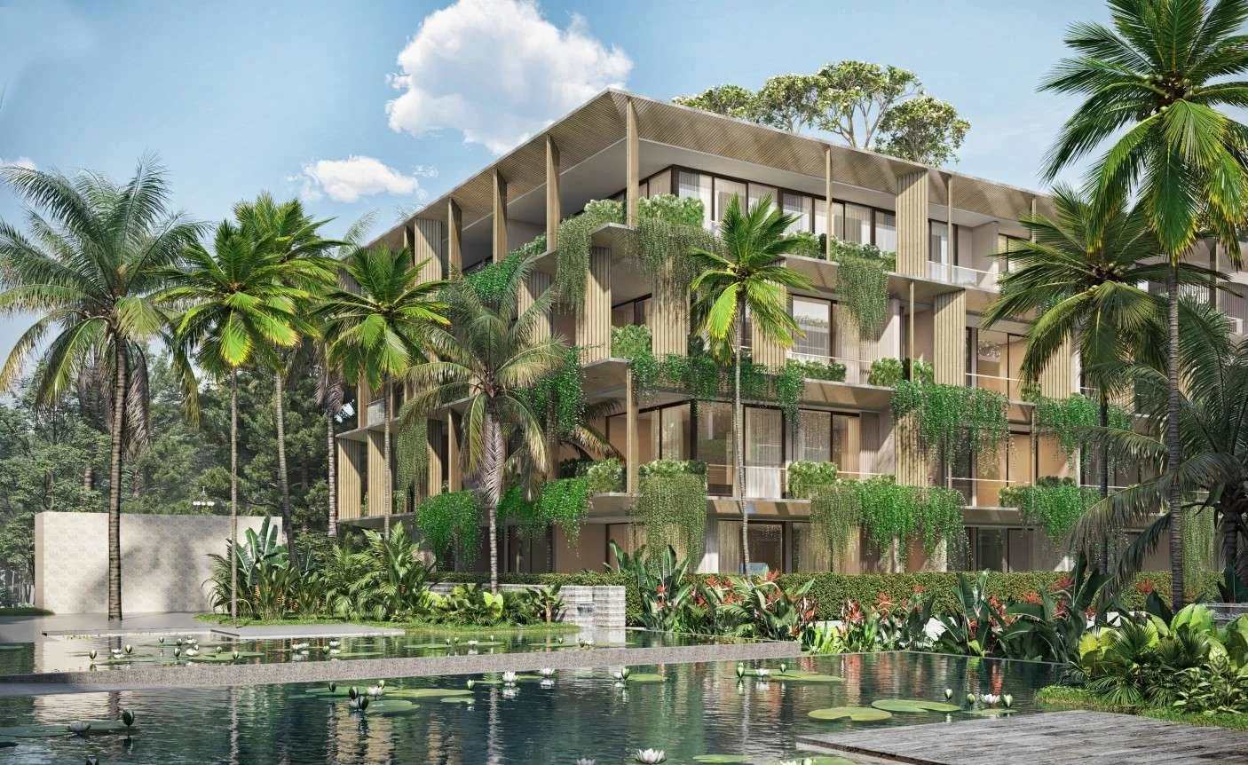 Exterior view of Eden Residences at Gardens of Eden Phuket, showing a low-rise tropical design with lush landscaping and water features.