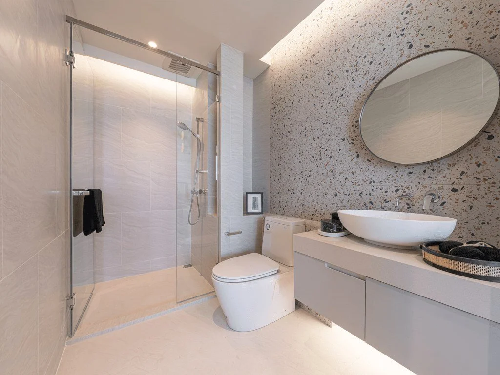 Modern bathroom interior at Vehha Hua Hin with walk-in shower and terrazzo-style wall finish in Hua Hin, Thailand.