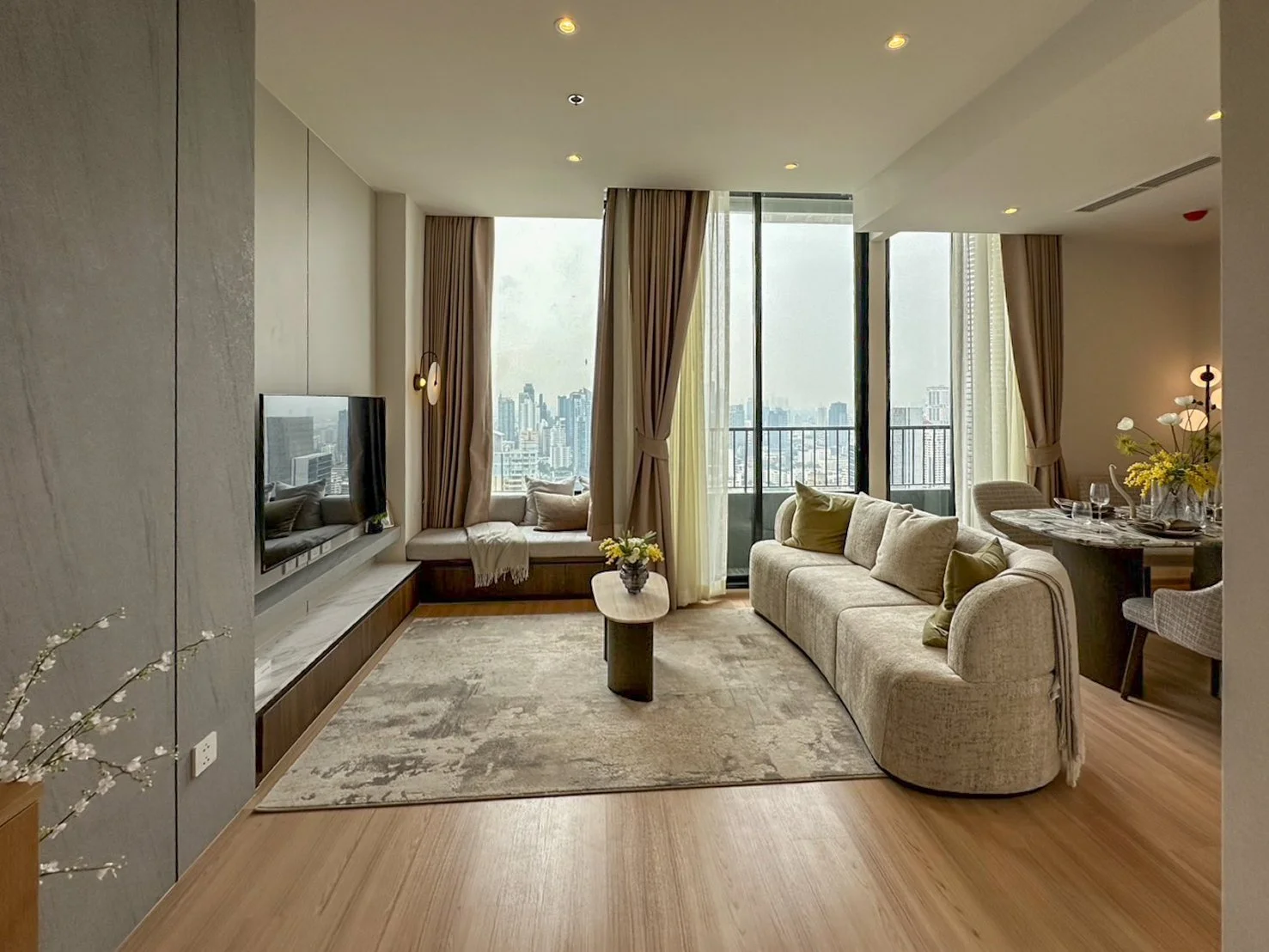 Living room at Noble Form Thonglor with sofa, balcony and Bangkok skyline views.