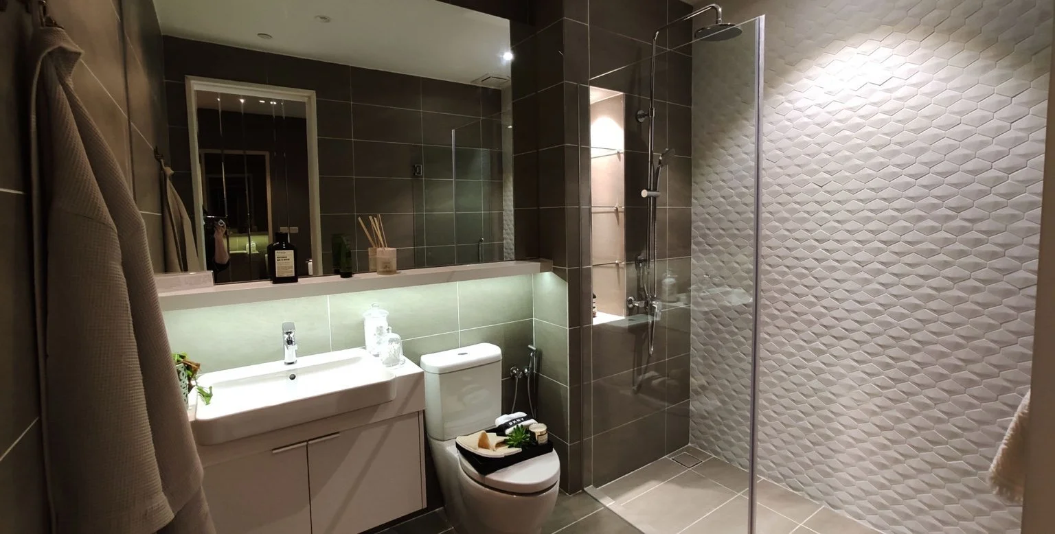 Stylish bathroom at Quill Residences featuring modern fixtures, walk-in shower, and warm lighting.