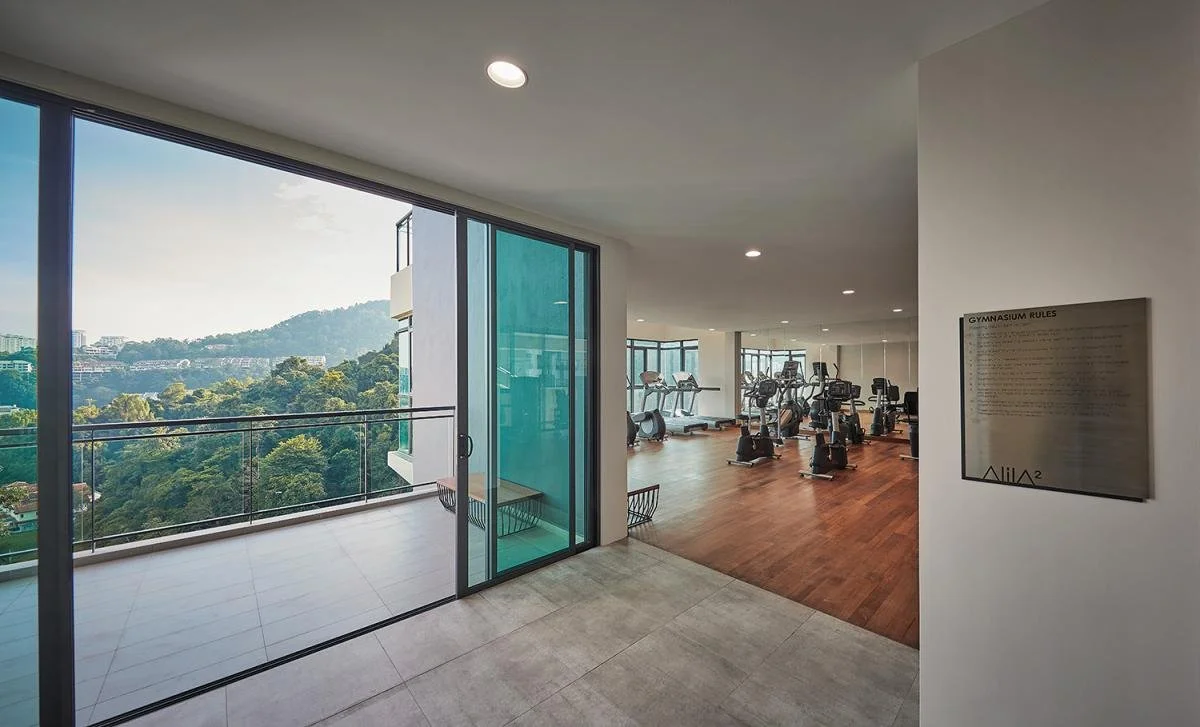 Fully equipped gymnasium at Alila² with balcony overlooking greenery.
