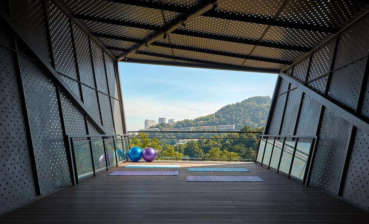 Covered yoga deck at Alila² Penang with open-air design and views towards surrounding greenery.