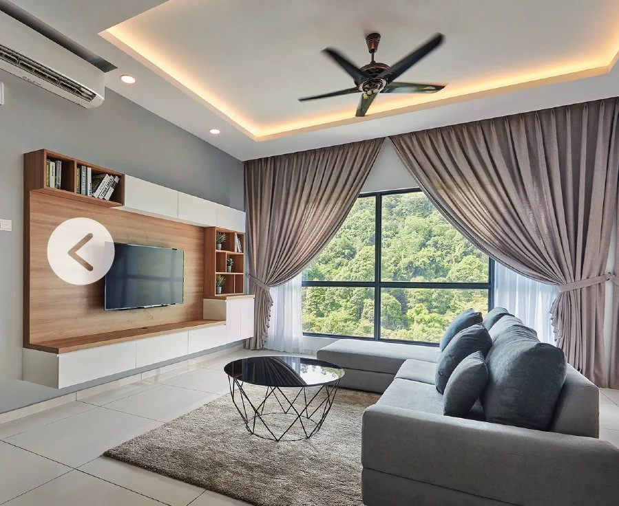Living area in Alila² Penang Type C unit with large windows overlooking hillside greenery and modern built-in TV wall.
