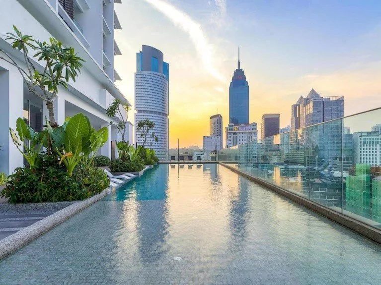 infinity pool at Quill Residences overlooking Kuala Lumpur city skyline with modern high-rises.