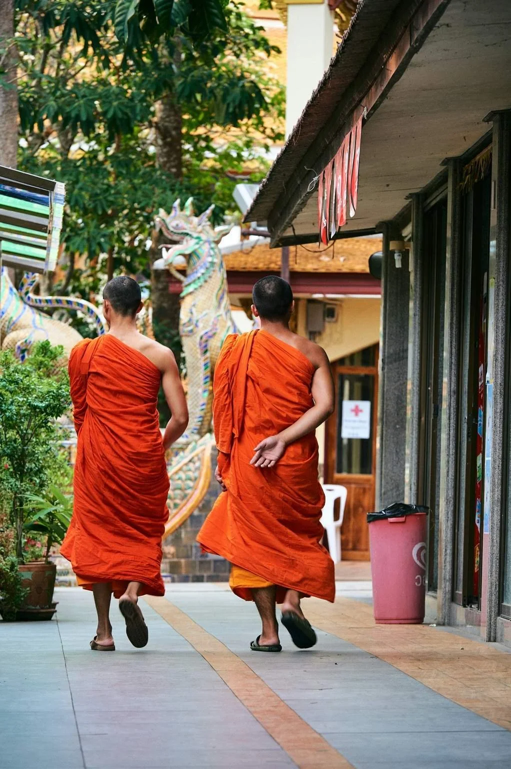 Monks walking through a temple courtyard in Chiang Mai, showcasing traditional Thai culture and lifestyle.