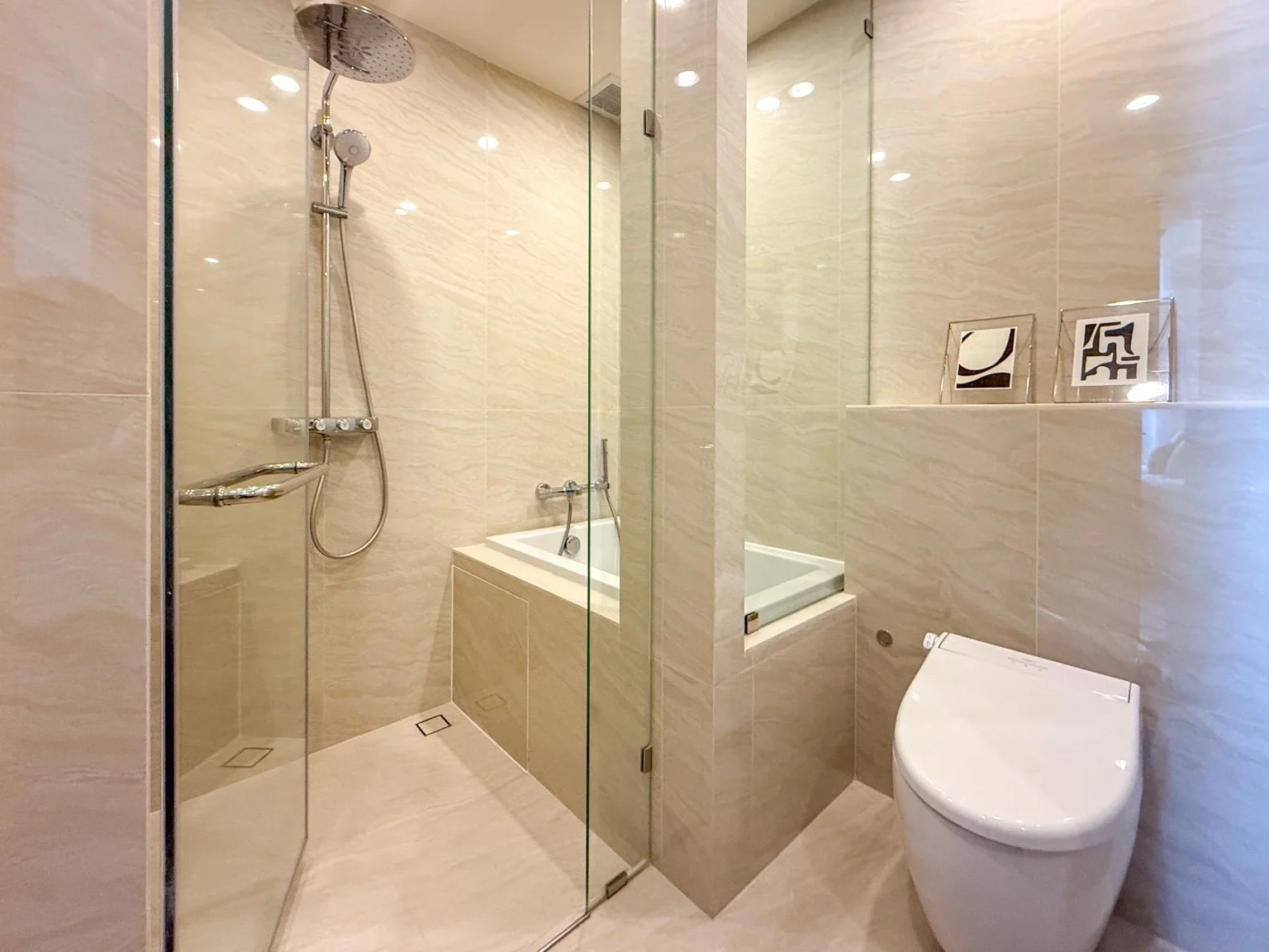 Bathroom at Noble Form Thonglor with walk-in shower, bathtub and modern fittings.