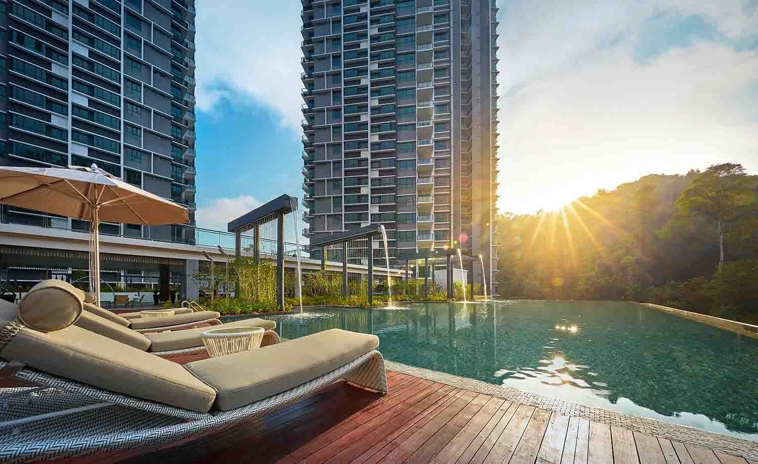 Swimming pool and sun deck at Alila² Tanjung Bungah, Penang, with landscaped greenery and high-rise residential towers in the background.