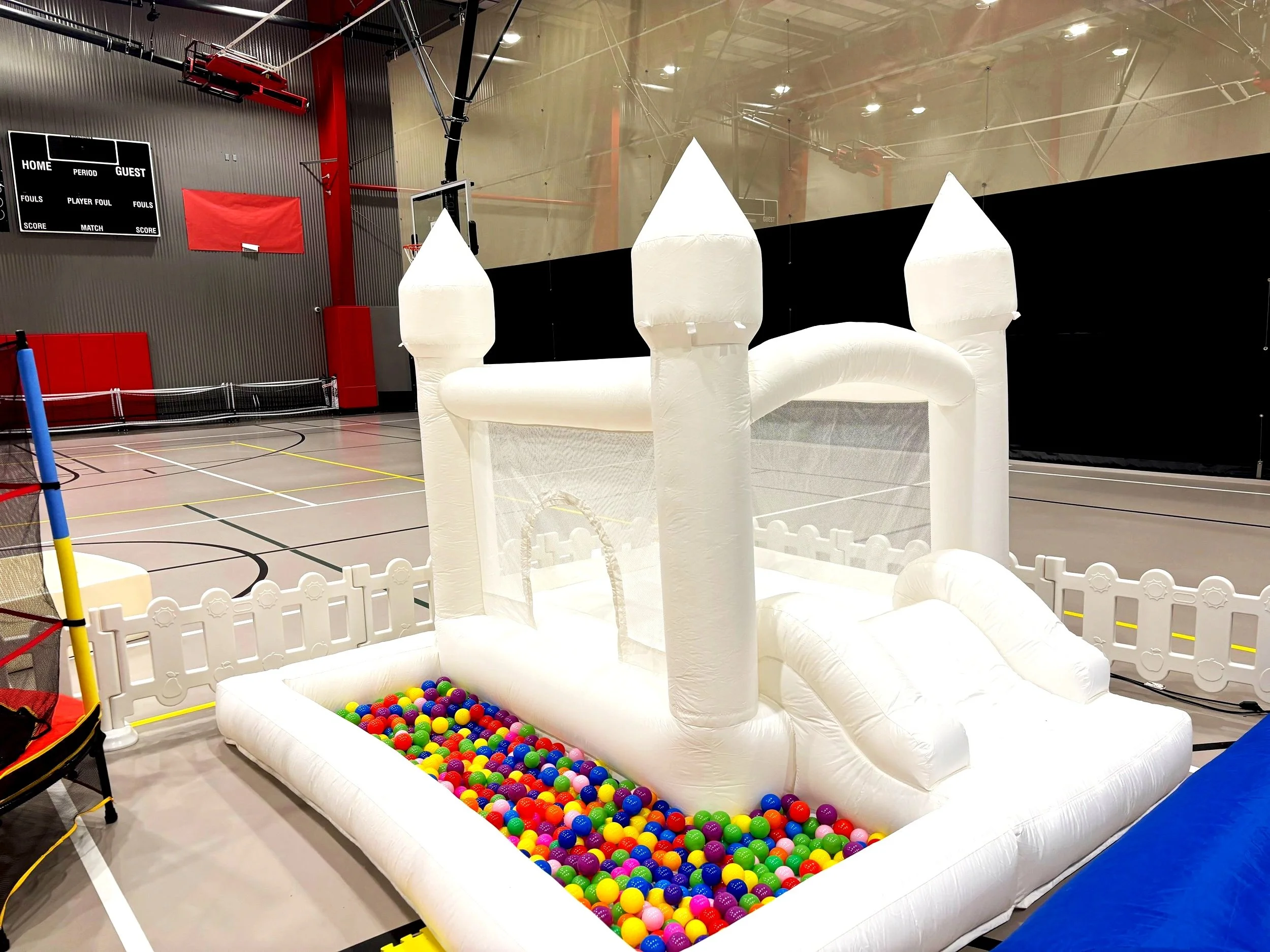 White bounce house with a ball pit.