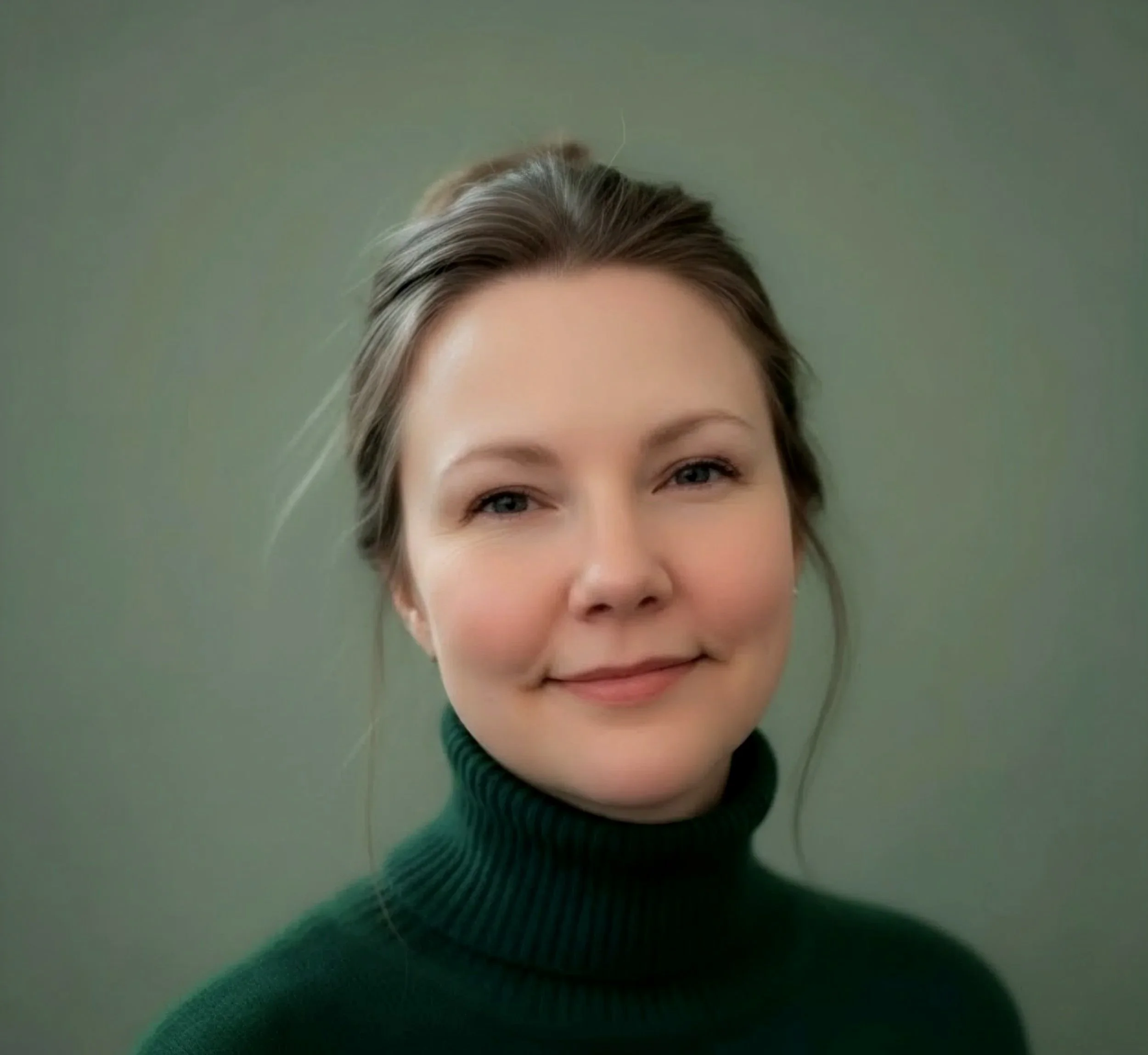 Close-up photo of a nonbinary face, showing a forehead, eyes, and nose, wearing a dark turtleneck sweater against a plain green background.