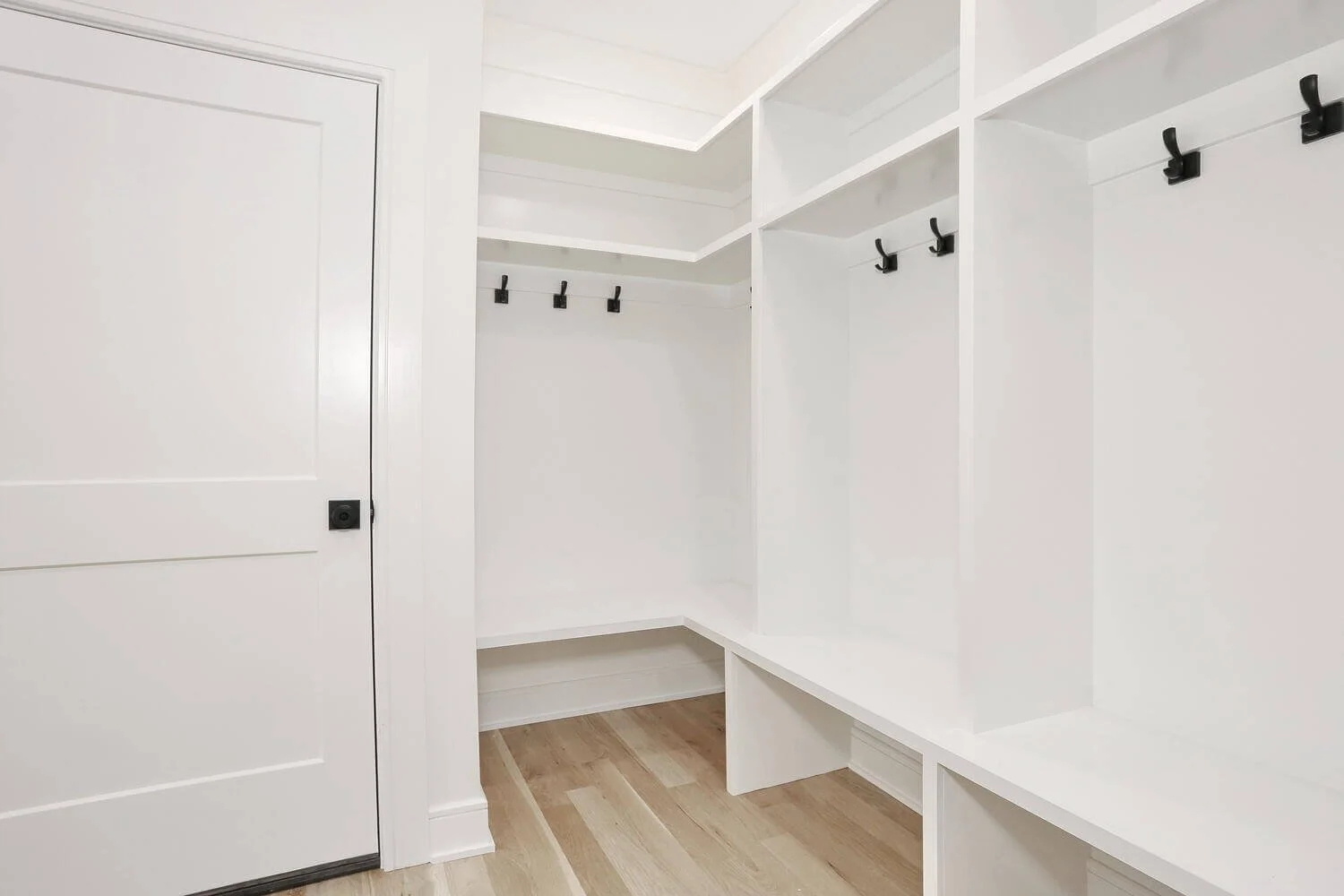 Custom mudroom with built-in shelving, bench seating, and storage hooks in a modern farmhouse by Dadak LLC, Park Ridge, NJ.