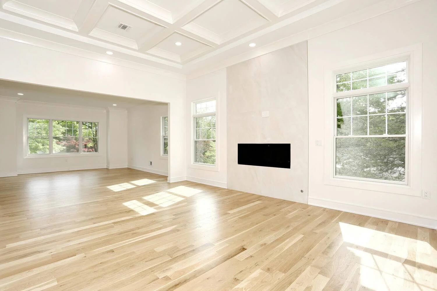 Connected family and dining rooms with large windows and natural light in a modern farmhouse built by Dadak LLC, Park Ridge, NJ.