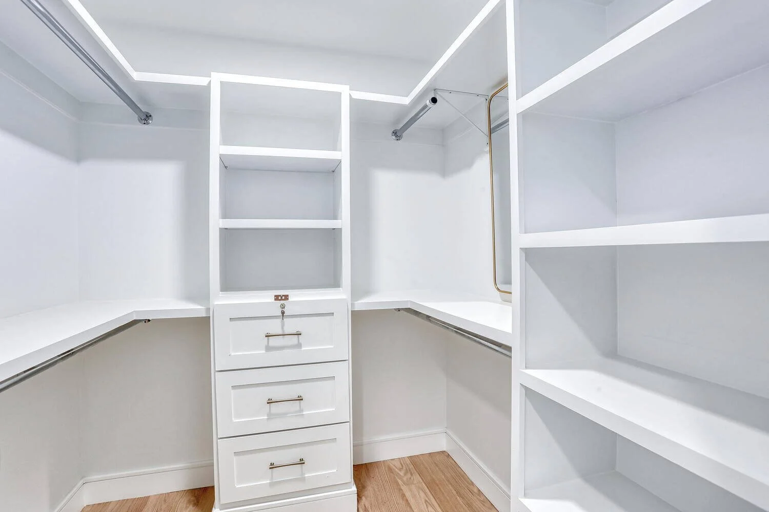 Spacious primary walk-in closet with custom built-in shelving and drawers in Montvale home.