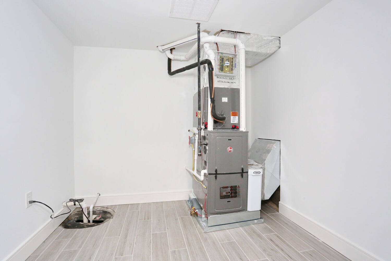 Mechanical room showing HVAC system and ductwork installation in a Park Ridge modern farmhouse by Dadak LLC.