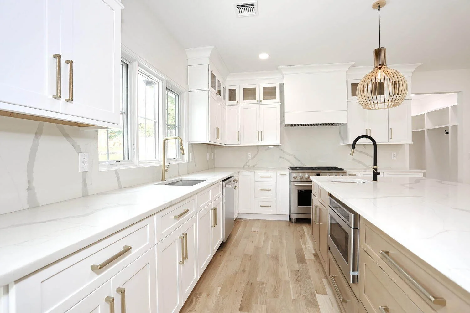 Bright kitchen featuring quartz countertops, stainless steel gas range, and marble-style backsplash in a Park Ridge modern farmhouse by Dadak LLC.