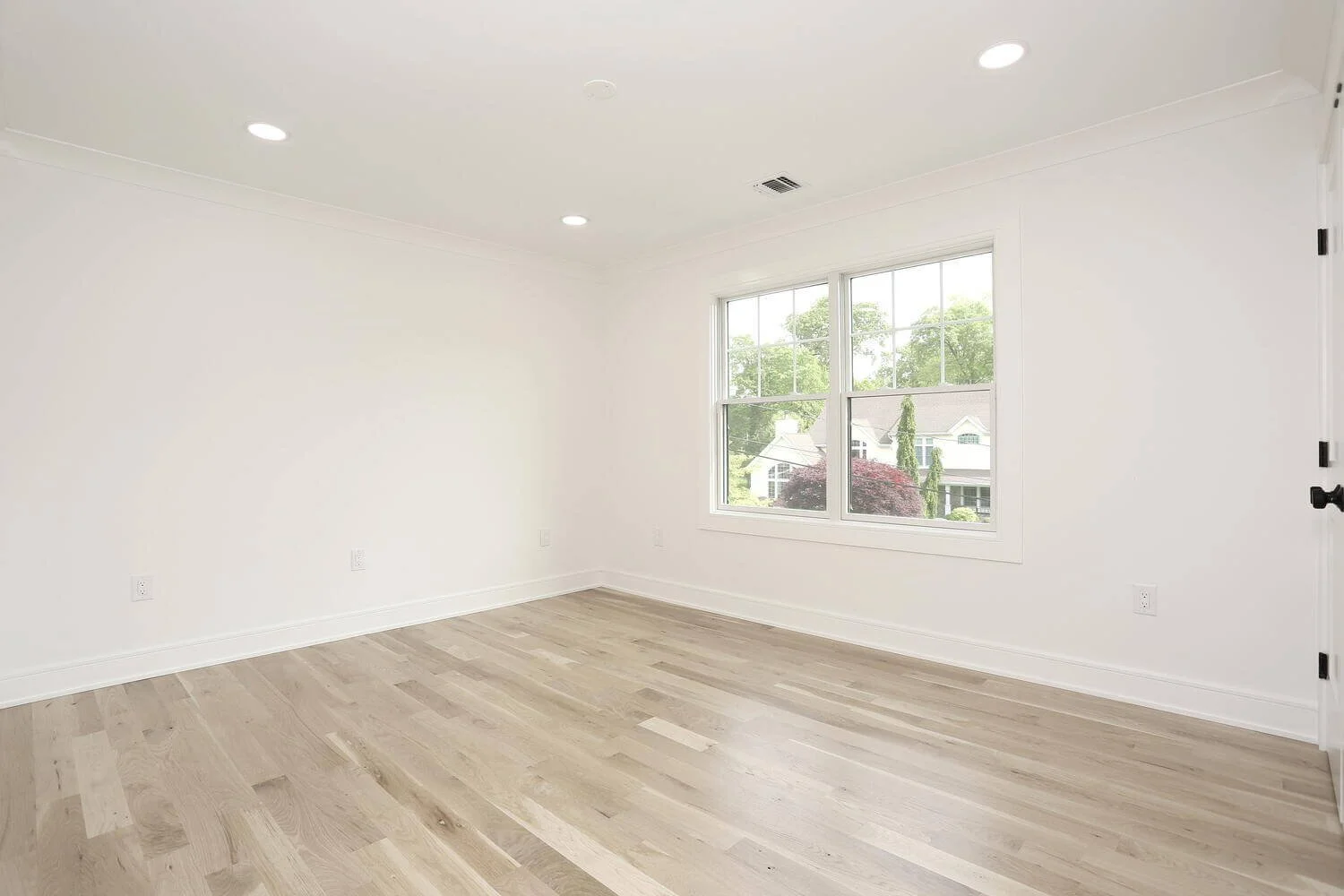 Bedroom with large window and closet space overlooking green backyard in a Park Ridge modern farmhouse by Dadak LLC.