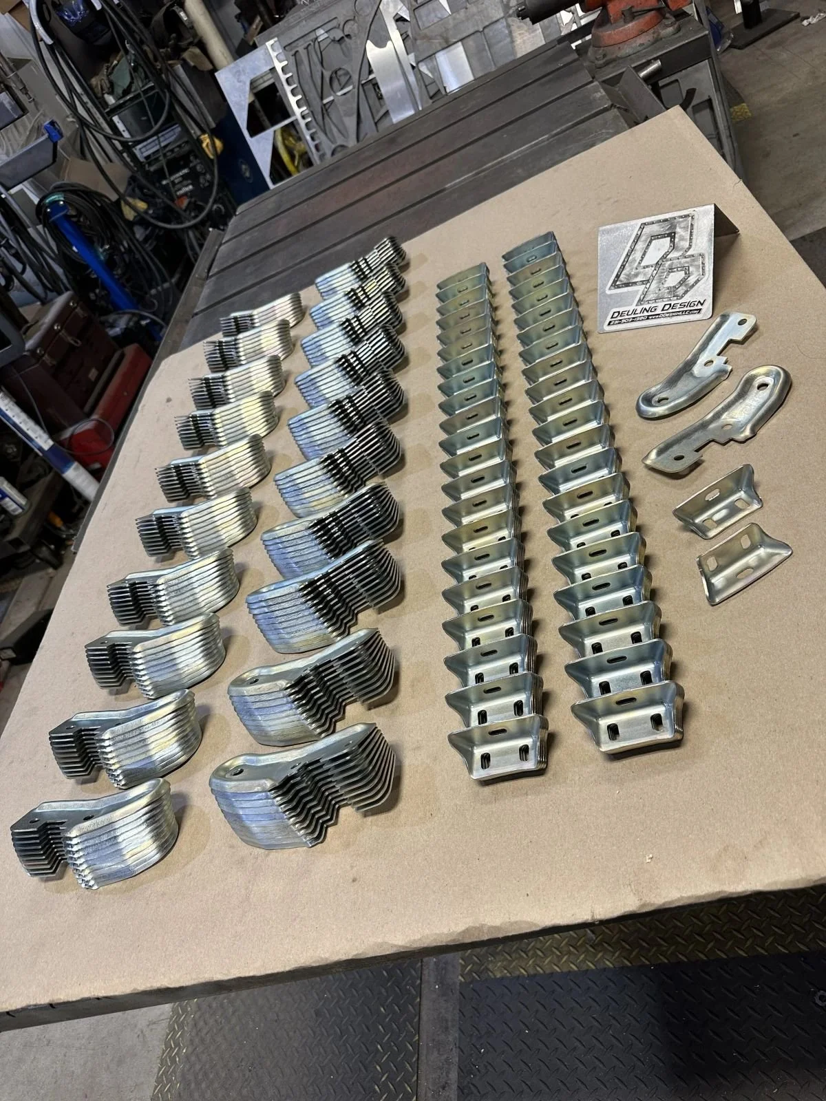 Another angle of stamped zinc plated metal components and tooling for Motor City K5 arranged on a worktable.