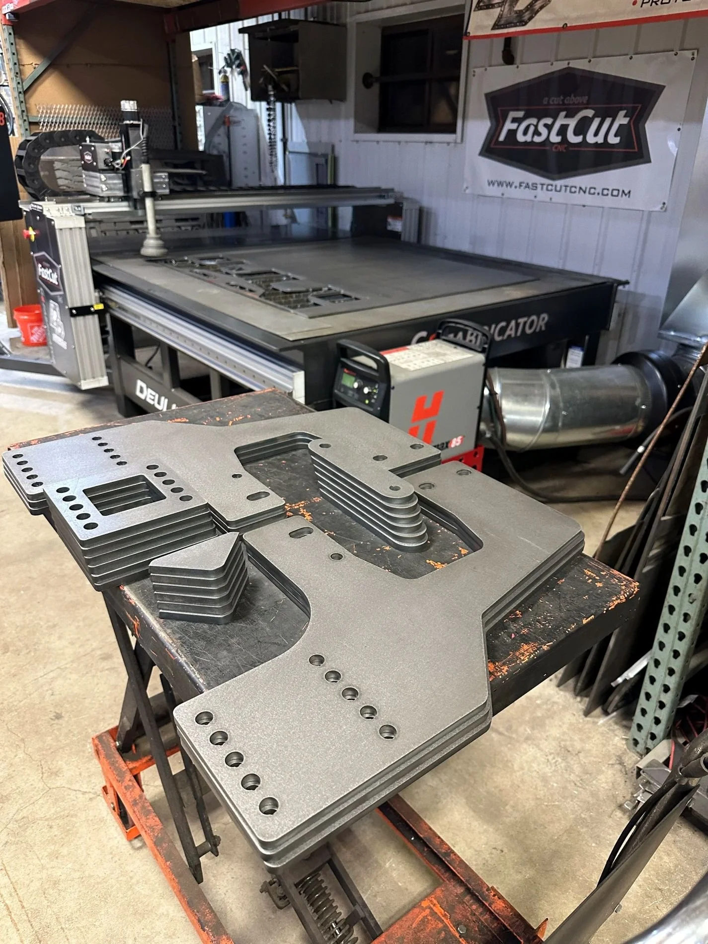 Stack of precision CNC plasma-cut steel components produced for a custom fabrication project.